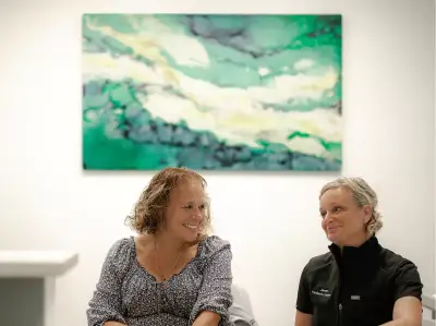 Happy patient reviewing screw-free dental implant results with Smileloc coordinator